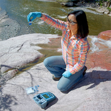 Field technician testing water sample with Hach portable equipment